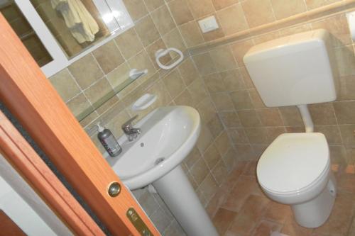 ein Badezimmer mit einem weißen WC und einem Waschbecken in der Unterkunft Casa Delle Olive in Dolceacqua