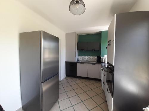Il comprend une cuisine équipée d'un grand réfrigérateur en acier inoxydable. dans l'établissement Charmant T3 rénové avec jardin et garage, centre-ville de La Roche-Posay - FR-1-541-99, à La Roche-Posay