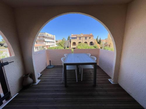 une table et des chaises sur un balcon avec une voûte dans l'établissement Appartement T2 climatisé, rénové, proche plage, avec terrasse et parking - Port Leucate - FR-1-81-586, à Port-Leucate