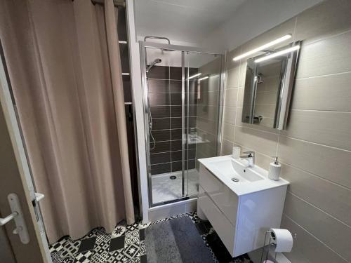 une salle de bain avec un lavabo blanc et une douche dans l'établissement Appartement T2 climatisé, rénové, proche plage, avec terrasse et parking - Port Leucate - FR-1-81-586, à Port-Leucate