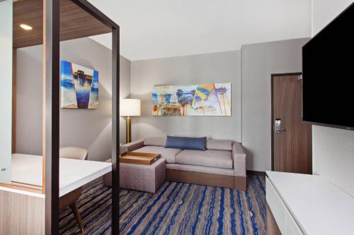 a living room with a couch and a table at SpringHill Suites by Marriott Huntington Beach Orange County in Huntington Beach