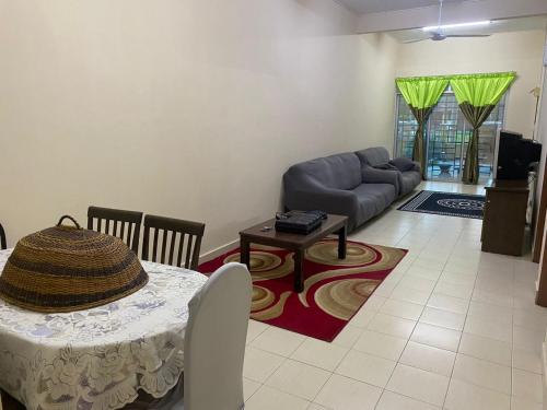 uma sala de estar com uma mesa e um sofá em Ajila Inn em Sepang