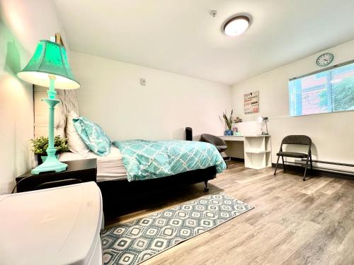 a bedroom with a bed and a desk with a lamp at Studio Apartment with Shared Bathroom 10 minutes walk to University of WA in Seattle