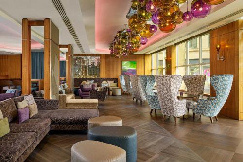 a lobby with couches and chairs and a bar at Sheraton Grand Hotel & Spa in Edinburgh
