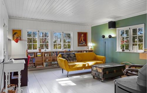 a living room with a yellow couch and a book shelf at Beautiful Home In Munke Bjergby With Kitchen in Munke Bjergby
