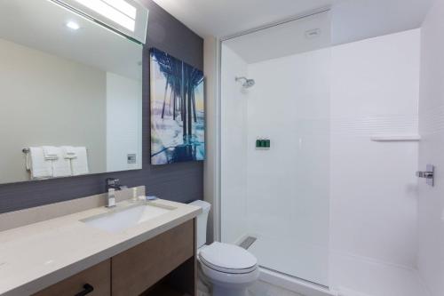 a bathroom with a sink and a toilet and a mirror at TownePlace Suites by Marriott San Diego Central in San Diego