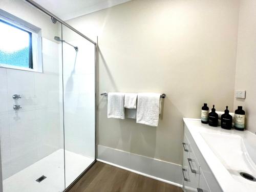 y baño con ducha y lavamanos. en Villa on Melbourne St en Adelaida