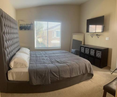 a bedroom with a large bed and a television at Gorgeous home away from home in Las Vegas