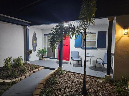 a house with a red door and a palm tree at Beautiful Clearwater home! in Clearwater