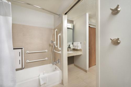 a bathroom with a shower and a tub and a sink at Courtyard Mishawaka-University Area in South Bend