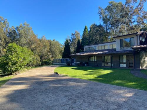 a driveway leading to a house with trees in the background at Bawley Point accommodation in Bawley Point