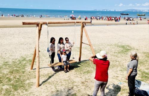 a group of people on a swing on the beach at Nguyễn Kim Motel in Long Hai