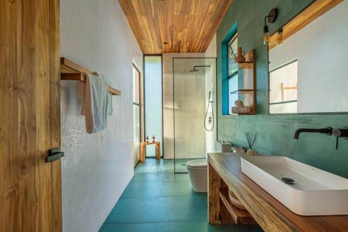 a bathroom with a tub and a sink and a mirror at The L Design Villa in Carmen