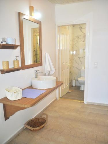 a bathroom with a sink and a mirror at Beachfront Vacation Home eftichia in Agios Gordios