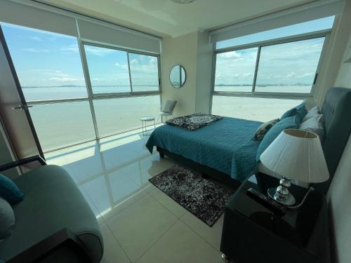 a bedroom with a bed and a view of the ocean at Apartamento VISTA Al RIO PUERTO SANTANA Riverfront 1 in Guayaquil