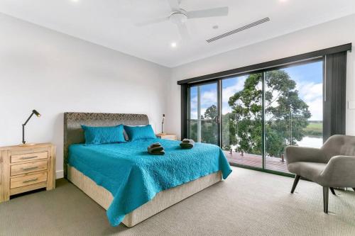 a bedroom with a bed and a chair and a large window at Platinum on Washpool in Wellington East