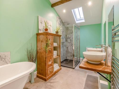a bathroom with a tub and a sink at The Parlour - Uk41748 in Loppington
