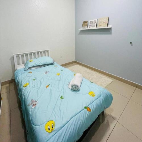 a bedroom with a bed with a blue comforter with smiley faces on at Wallaway2stay Kiara Nilai Apartment 3 Bedroom in Nilai
