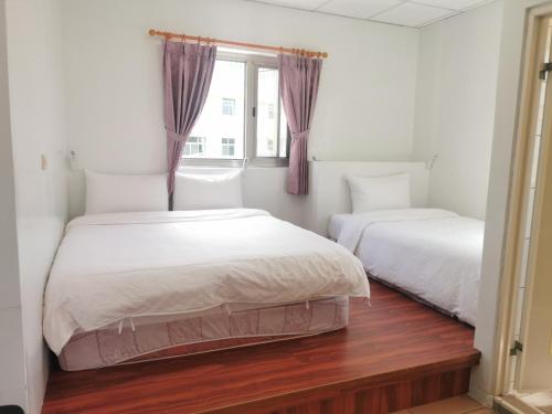 樂野村的住宿－新天山茶業民宿，一间卧室设有两张床和窗户。