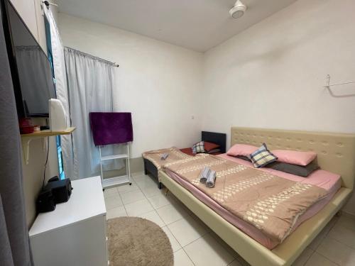 a bedroom with two beds and a tv in it at GS24 Muar in Muar