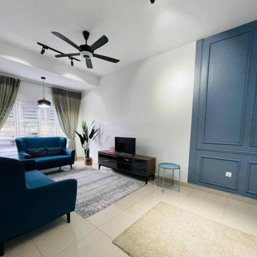 a living room with a blue couch and a tv at Wallaway2stay Kiara Nilai Apartment 3 Bedroom in Nilai
