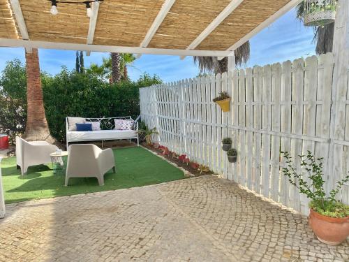 a patio with a white fence and a table and chairs at Casa Pedra Rosa - VINHAS de NEXE in Faro