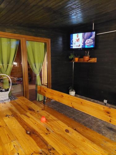 a living room with a bench and a tv on a wall at Cabana Oprișor in Ocna Sibiului
