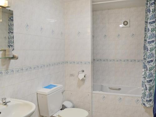 a bathroom with a toilet and a sink and a shower at Barn End Cottage in Millers Dale