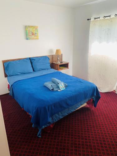 a bedroom with a blue bed with a hat on it at Theodore Motor Hotel in Theodore