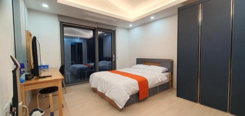a bedroom with a bed and a desk and a television at High-Quality House Ocean view in Tongyeong