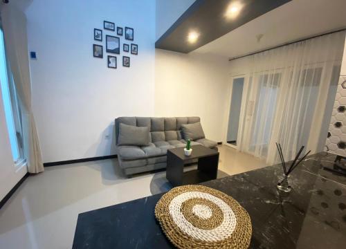 a living room with a couch and a table at Villa Royal Arois Syariah Dekat Jatim Park 3 in Tlekung