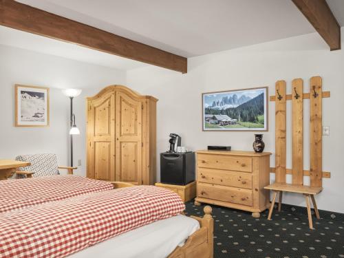 a bedroom with two beds and a wooden cabinet at Hotel Pension Anna in Leavenworth