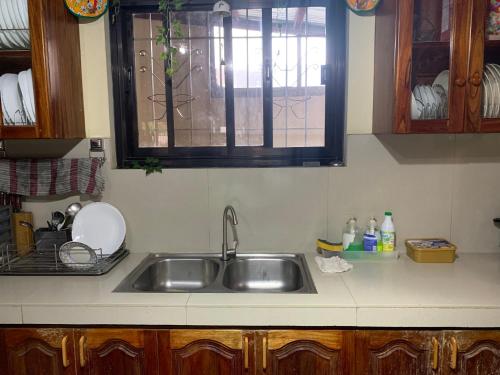 a kitchen counter with a sink and a window at Baguio Woodsgate Lodging Home in Baguio