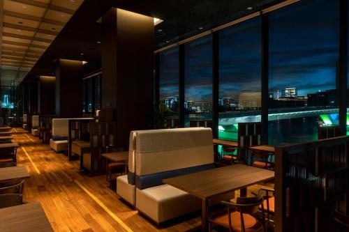 a restaurant with a view of a pool and tables and chairs at La Vista Tokyo Bay in Tokyo