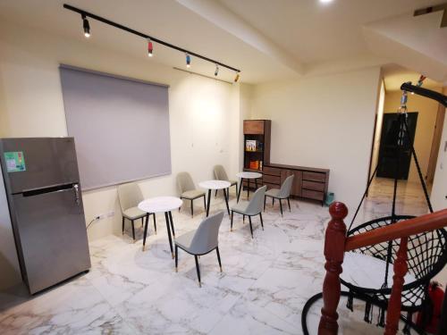 una sala de reuniones con mesas, sillas y una pizarra en 小短腿的家-無人化民宿, en Taitung