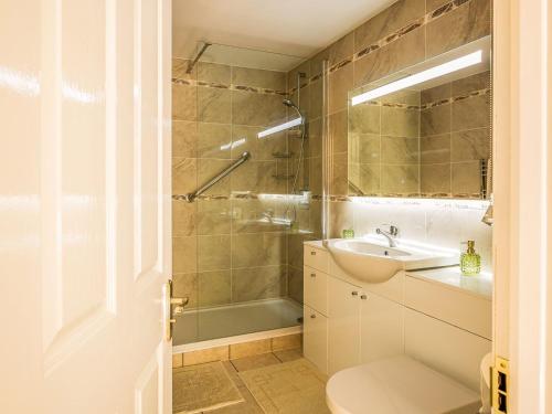 W łazience znajduje się umywalka, toaleta i prysznic. w obiekcie Kennel Cottage w mieście Alwinton
