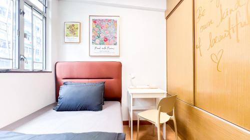 een kleine slaapkamer met een bed en een stoel bij Shared Apartment Lockhart Road 384 in Hong Kong