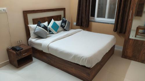 a bedroom with a large bed with white sheets and pillows at Hotel Greenoz in Jaipur