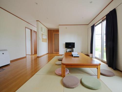 Cottage Pastorale في فوجيكاواجوتشيكو: غرفة معيشة مع طاولة قهوة وسجادة كبيرة