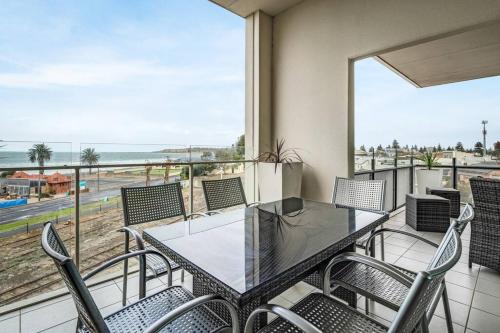 a balcony with a table and chairs and a view of the beach at Penthouse 406 The Frontage Victor Harbor in Victor Harbor