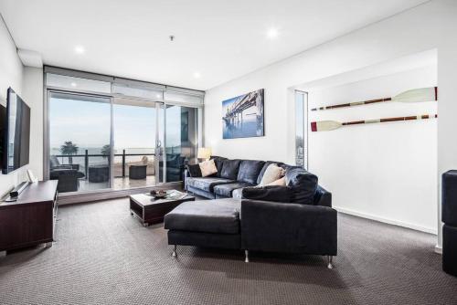 a living room with a couch and a tv at Penthouse 406 The Frontage Victor Harbor in Victor Harbor