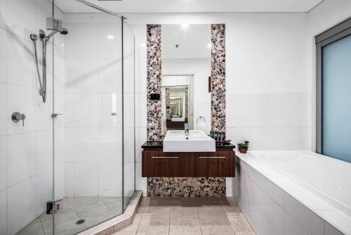 uma casa de banho com uma banheira, um lavatório e um chuveiro em Penthouse 406 The Frontage Victor Harbor em Victor Harbor