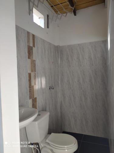 Łazienka z białą toaletą i umywalką w obiekcie Apartamentos Olaya! w mieście Bahía Solano