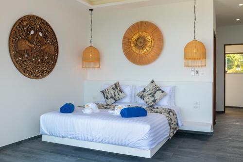 a bedroom with a white bed with blue pillows at BLUE BUTTERFLY Luxury Pool Villa Koh Samui 5 Bedrooms in Koh Samui 