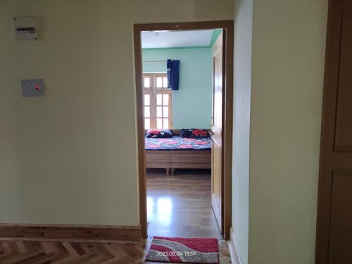 a hallway with a door open to a bedroom with a bed at Valley View Homestay Lahaul in Gondla