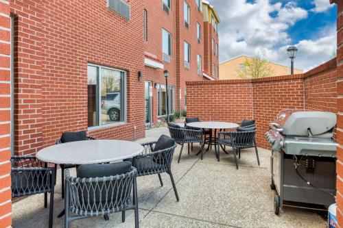 a patio with tables and chairs and a grill at TownePlace Suites by Marriott Dallas McKinney in McKinney