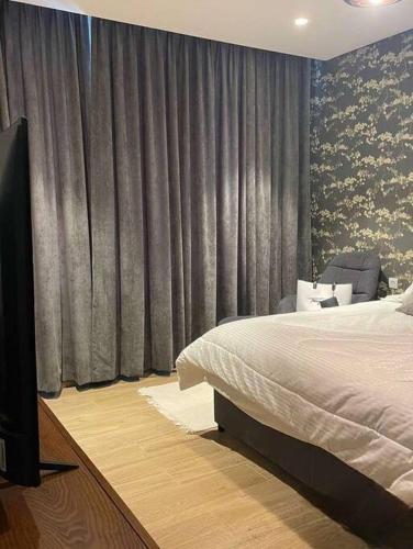 1 dormitorio con 1 cama y TV en Apartment in Millennium Resort luxurious, en Salalah