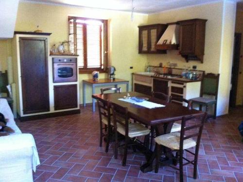 a kitchen with a table and chairs and a kitchen with a stove at Ospitaci Appartamenti di campagna Le Rancole in Valtopina