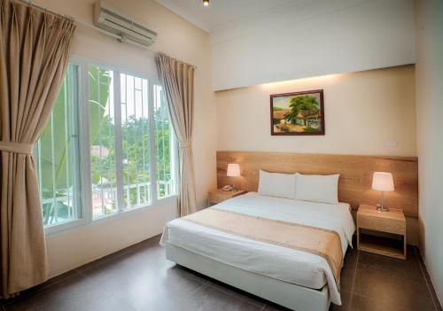 a bedroom with a bed and a large window at VResort Kim Boi - Hoa Binh in Hòa Bình