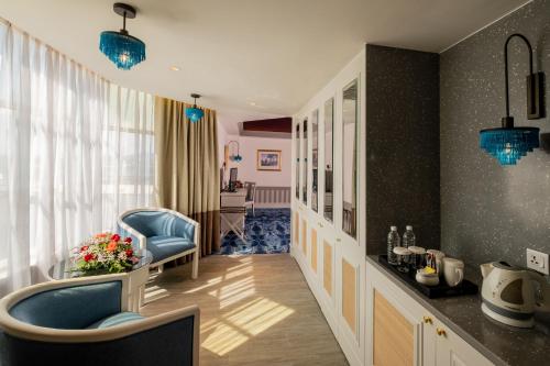 馬六甲的住宿－Grand Swiss-Belhotel Melaka - formerly LaCrista Hotel Melaka，客厅配有蓝色椅子和桌子